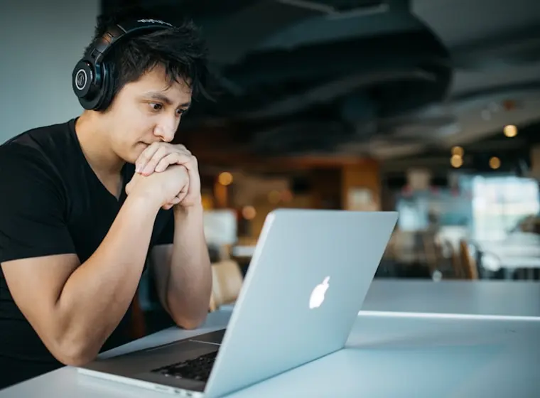 Quloqchin taqqan yigit noutbukda online ingliz tili o'rganmoqda